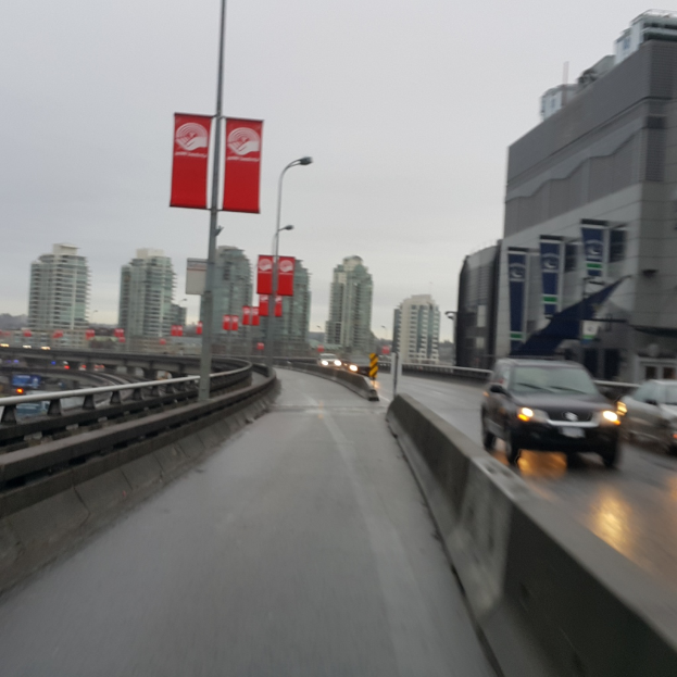 Eine fast leere Straße mit Gebäuden im Hintergrund und mehreren Pfählen in der linken Ecke.