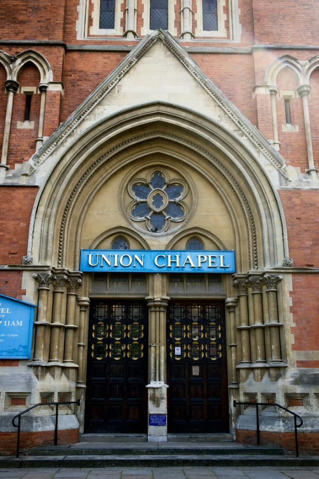 Eine große historische Kirche in London mit zahlreichen Fenstern an ihren Wänden und zwei Türen am Eingang.