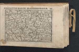 Ein offenes Buch mit einer detaillierten Karte von Brandenburgs geografischen Merkmalen auf einer schwarzen Oberfläche.