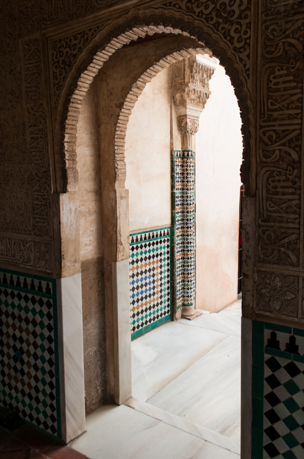 Ein Blick auf den Eingang eines Gebäudes von innen, der eine Tür und etwas Grünzeug draußen zeigt.