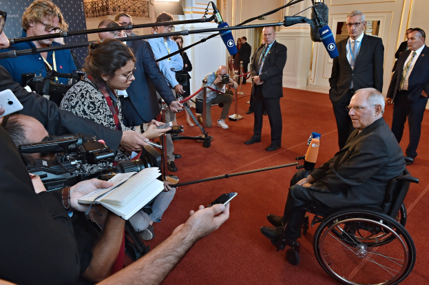 Ein Mann im Rollstuhl wird von Reportern mit Kameras, Mikrofonen und Handys umgeben.