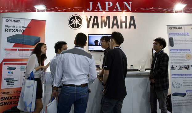 Eine Frau steht mit einem Röhrchen in der Hand, mit lesbarem Text und einem Datum in der linken unteren Ecke vor einem weißen Hintergrund.