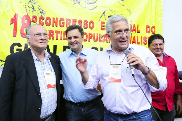 Ein Mann spricht in ein Mikrofon vor einem gelben Vorhang mit der Aufschrift "18 Grad Kongress O"