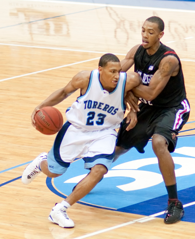 Zwei Personen spielen Basketball, wobei eine Person den Ball in der Mitte hält.