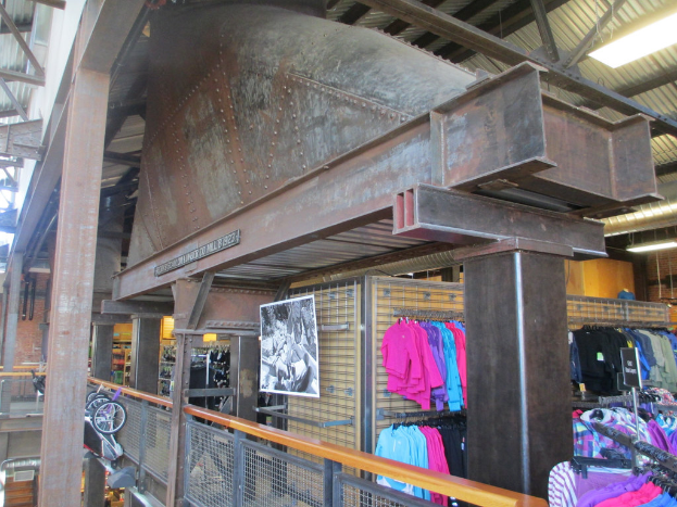 Eine Szene mit verschiedenen Kleidungsstücken, beleuchteten Lichtern, Metallstangen, Karren und einem Zaun.