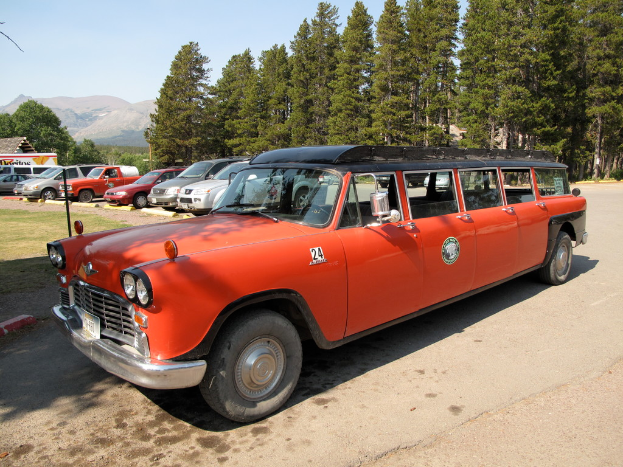 Eine Straße mit Autos, Bäumen auf beiden Seiten und einem Himmel darüber.