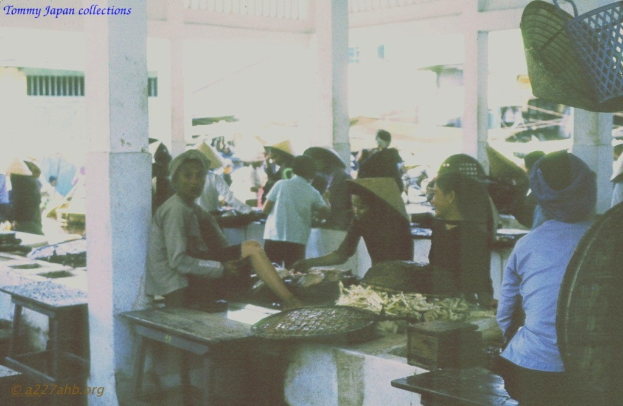 Eine Gruppe von Menschen, einige sitzen und einige stehen, wobei die meisten Hüte tragen.