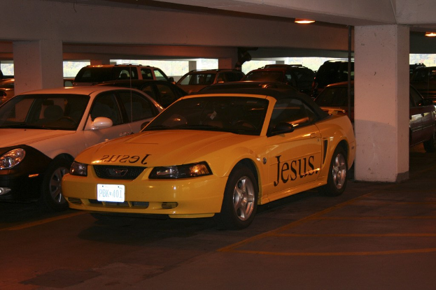 Ein Parkplatz mit zahlreichen geparkten Autos vor einem Gebäude.