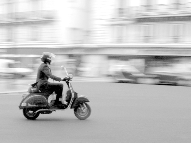 Eine Person f√§hrt ein Scooter auf einer Stra√üe.
