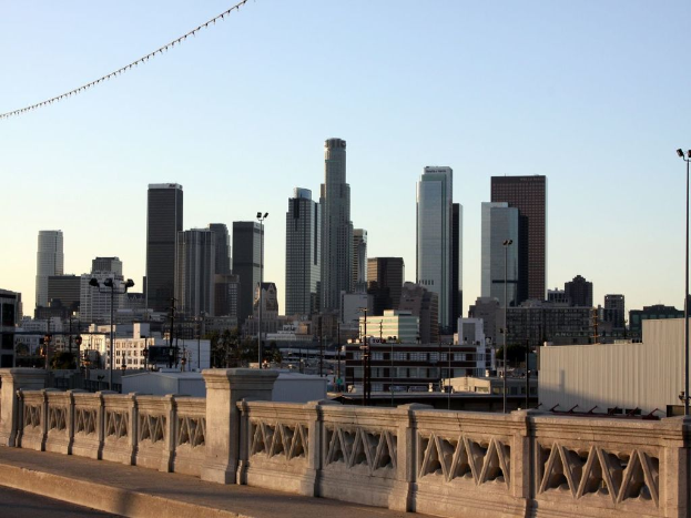 Ein Geländer im Vordergrund mit vielen hohen Gebäuden und Masten im Hintergrund.