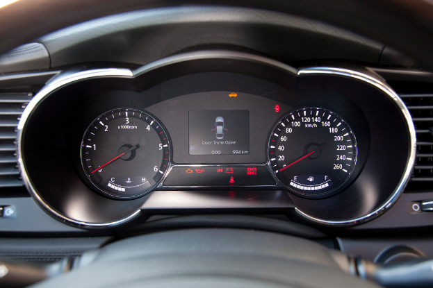 Ein Detailbild des Armaturenbretts eines Autos mit einem kleinen Bild eines Autos auf dem Bildschirm.