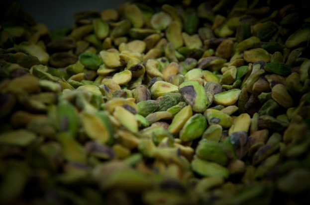 Ein Detailbild mehrerer Pistazien, das ihre charakteristischen grünen und violetten Schalen zeigt.