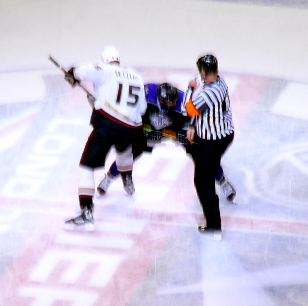 Drei Personen in Skikleidung und Helmen mit Skischuhen nebeneinanderstehend.