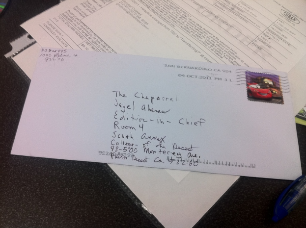 Ein Tisch mit Papier, einer Datei, einem Brief, einem Stift und einem unbekannten Objekt darauf.