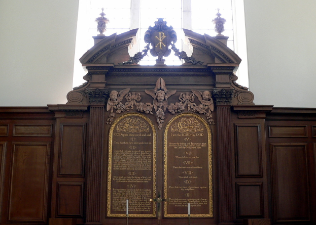 Ein Museumsplakette mit Text und Skulpturen darauf.