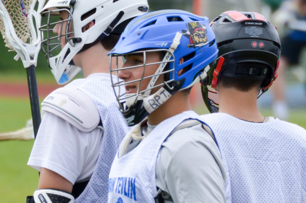 Drei Spieler in weißen Jacken und Helmen mit einem unscharfen Hintergrund.