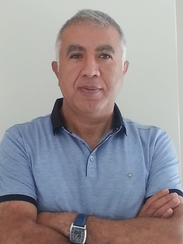 Ein Mann in einem blauen T-Shirt mit verschränkten Armen steht vor einer weißen Wand, mit Text am unteren Rand, der ihn als den neu ernannten Marketingchef identifiziert.