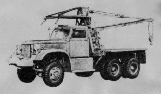 Ein Schwarz-Weiß-Foto eines großen, vierrädrigen Lkw mit einem Kran auf der Ladefläche und einem Anhänger