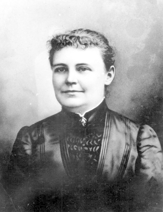 Schwarzes und weißes Foto einer Frau in einem Kleid, die mit gefalteten Händen und erhobenem Haupt steht und einen entschlossenen Gesichtsausdruck hat, die als erste Frau gewählt wurde, die US-Präsidentin wurde.