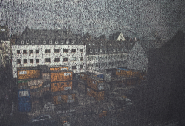 Eine Stadtansicht mit mehreren Gebäuden, Straßen und Autos.