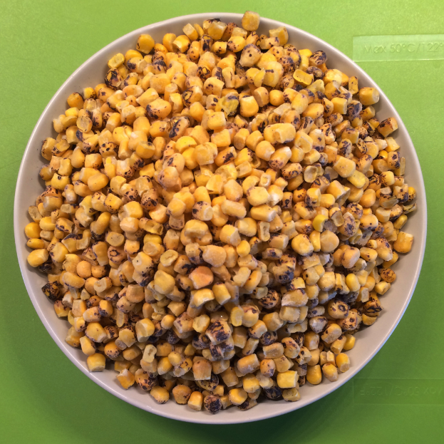 Ein weißer Schüssel gefüllt mit Maiskörnern auf einem grünen Hintergrund mit Text unten.