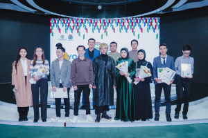 Eine Gruppe von Menschen auf einer Bühne mit Blumensträußen und Urkunden, vor einem Hintergrund mit der Aufschrift "Jugend-Solar-Awards 2019."