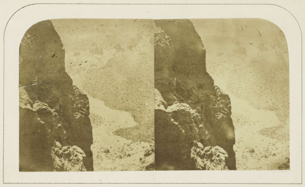 Schwarzes und weißes Foto einer felsigen Klippe mit dem Himmel im Hintergrund und Text unten.