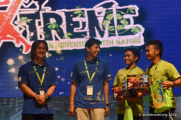 Menschen mit ID-Karten und einem Plakat im Hintergrund.