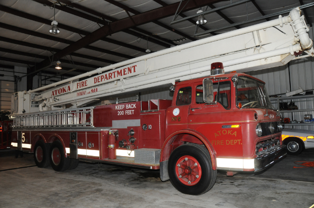 Ein Löschfahrzeug steht in einer großen Halle mit Deckenbeleuchtung.