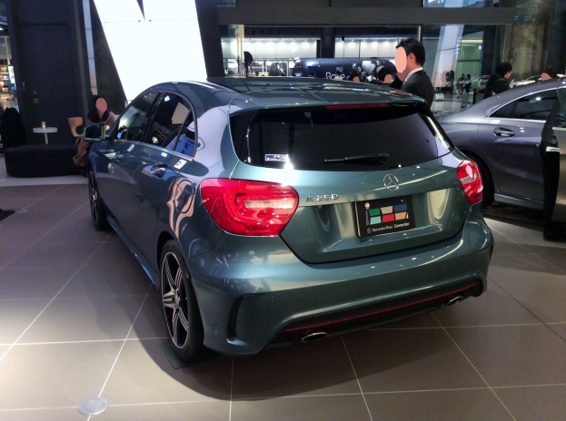 Ein Mercedes-Benz A-Klasse Hatchback mit glänzender schwarzer Lackierung und Chromakzenten, ausgestellt auf der IAA, umgeben von Menschen.