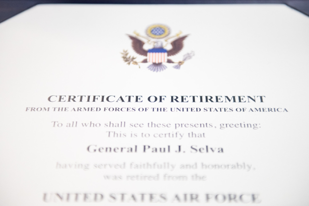 Blauer Rahmen mit einem Abzeichen der United States Air Force, das ein Schild mit einem zentralen Stern, einem Lorbeerkranz und einer 'Retirement'-Banderole zeigt.