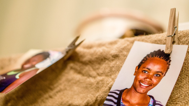 Auf einem Tisch liegen eine Klammer, ein Passfoto und ein Stoffstück auf der rechten Seite, mit einem unscharfen Hintergrund und linker Seite.