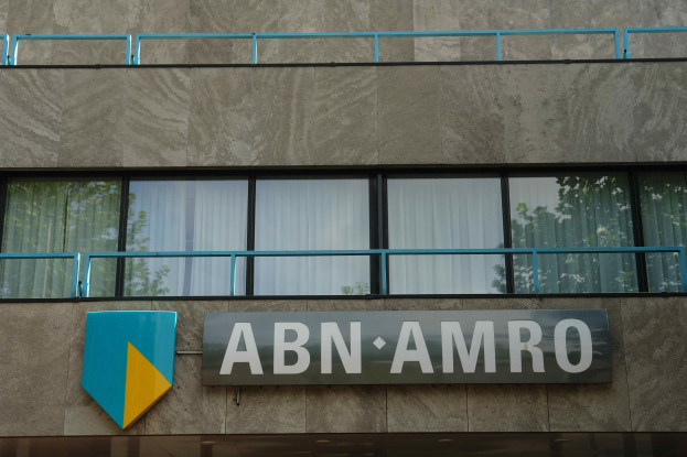 ABN AMRO-Hauptsitzgebäude mit einem Schild, einer Tafel, die seinen Status als Hauptsitz angibt, Geländern und Glasfenstern mit Vorhängen.