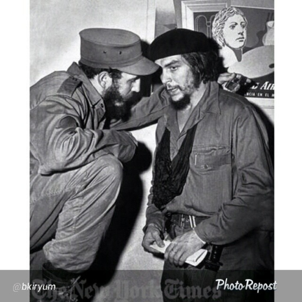 Zwei Personen sind in ein Gespräch vertieft mit einem gerahmten Bild und einer Wand im Hintergrund, und Text ist unten im Bild sichtbar.