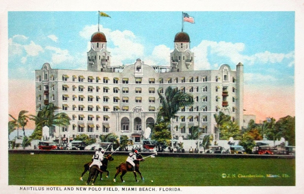 Postkarte des Nautilus Hotels und des neuen Polo Felds in Miami Beach, Florida, zeigt ein Gebäude mit Fenstern, Bäumen, Fahrzeugen, Menschen und einem bewölkten Himmel mit Text unten.