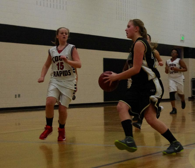 Eine Gruppe von Menschen, die Basketball in einem Innenraum mit einer Wand im Hintergrund spielen.