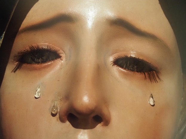 Eine Frau mit Tränen auf den Wangen, ihr Gesichtsausdruck spiegelt Trauer und Verzweiflung wider.